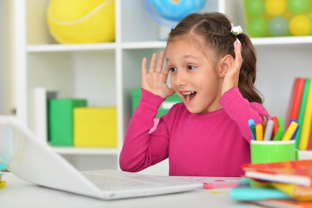 Porait de linda garota usando laptop em casa