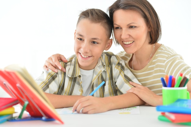 Foto porait de mãe com seu filho fazendo lição de casa em casa