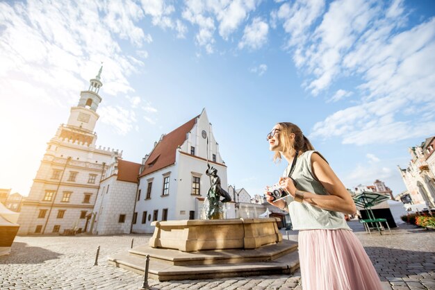 Porait de uma jovem turista viajando na velha praça do mercado na cidade de Poznan durante a luz da manhã na Polônia