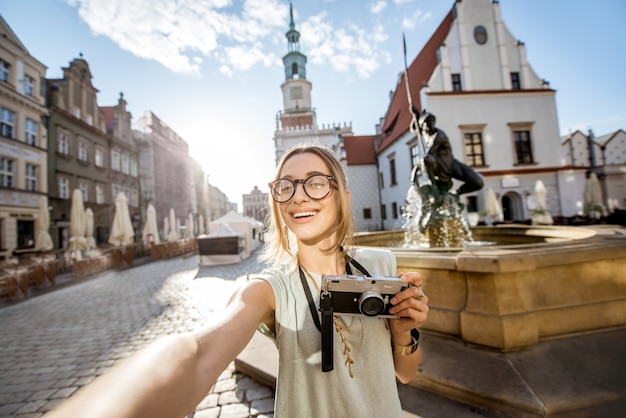 Porait de uma jovem turista viajando na velha praça do mercado na cidade de poznan durante a luz da manhã na polônia