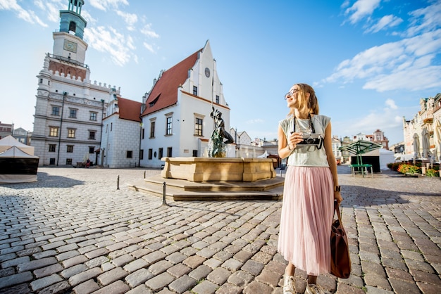 Porait einer jungen frau, die während des morgenlichts in polen auf dem alten marktplatz in posen unterwegs ist?