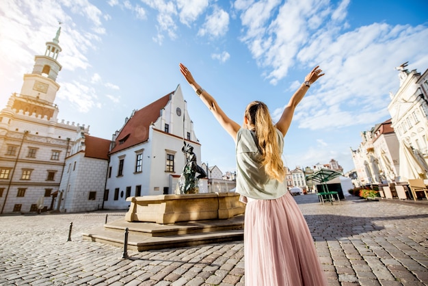 Porait de una joven turista que viaja en el antiguo mercado sqaure en la ciudad de Poznan durante la luz de la mañana en Polonia