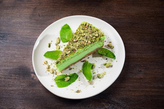 Porção de cheesecake de pistache com sabor matcha e hortelã Um pedaço verde brilhante de sobremesa em um prato