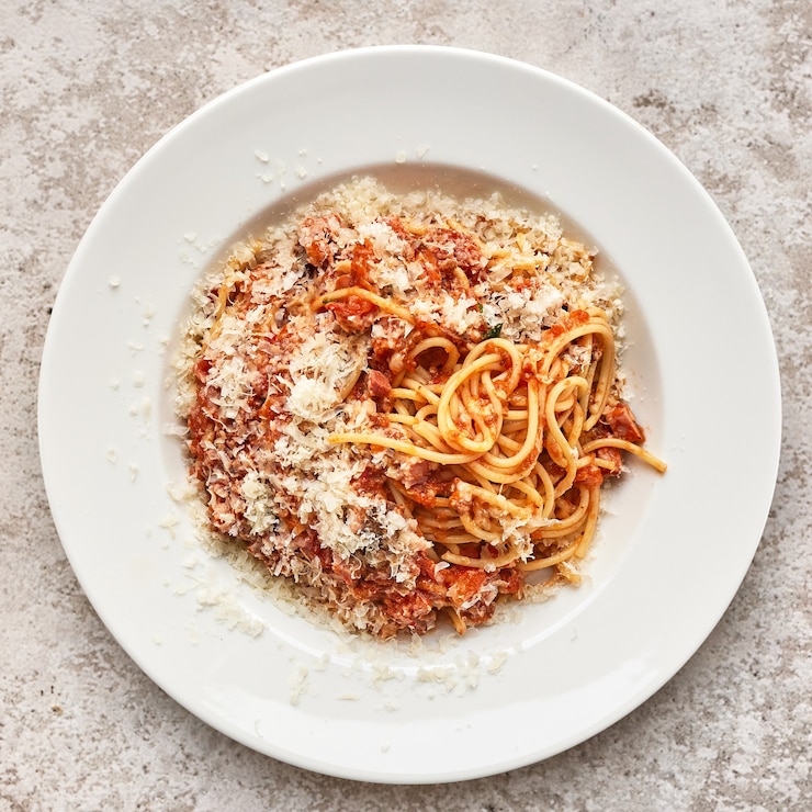 Foto porção de massa bolonesse no prato branco do restaurante, vista superior