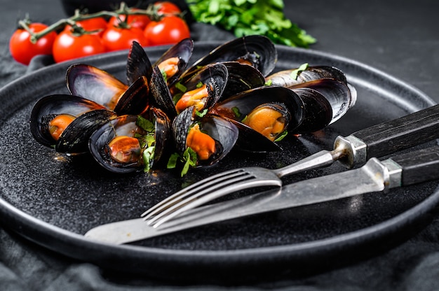 Porção de mexilhões deliciosos em molho de tomate e salsa. Vista do topo