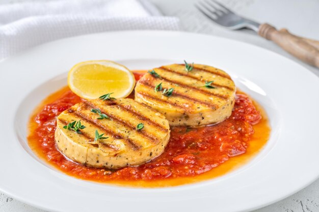 Porção de queijo grelhado com molho de tomate e manjericão