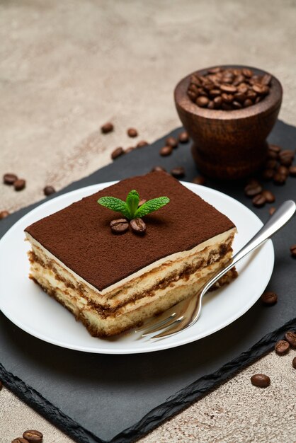 Porção de sobremesa tiramisu tradicional italiana na mesa de concreto cinza