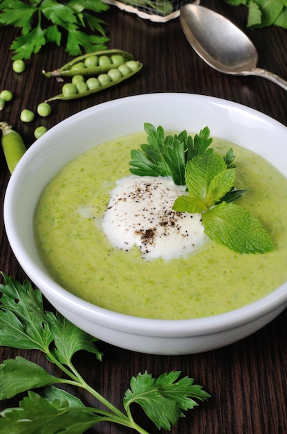 Porção de sopa de creme com ervilhas verdes com creme de hortelã