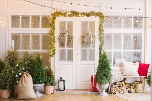 El porche de Navidad está decorado con pequeños árboles de Navidad y linternas.