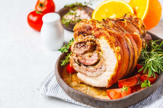 Porchetta al horno clásico italiano con naranjas, copia espacio.