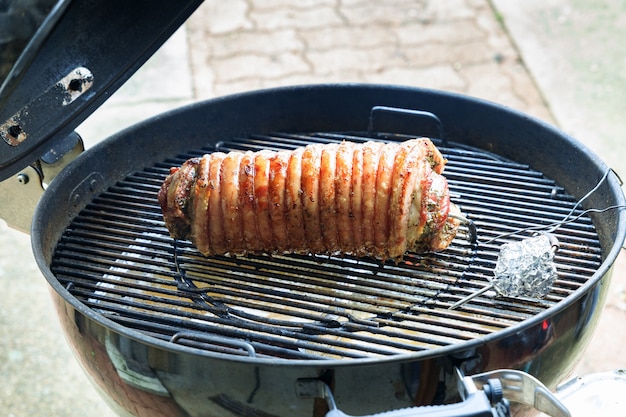 Porchetta se cocina en la barbacoa y se rocía con aceite de oliva