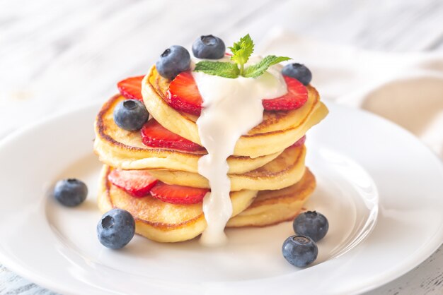 Porción de buñuelos de ricotta con bayas frescas