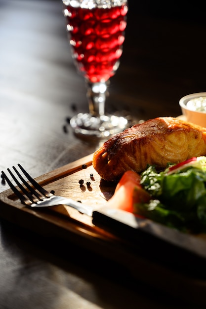 Porción de filete de salmón con hierbas en una mesa de madera. Vista superior