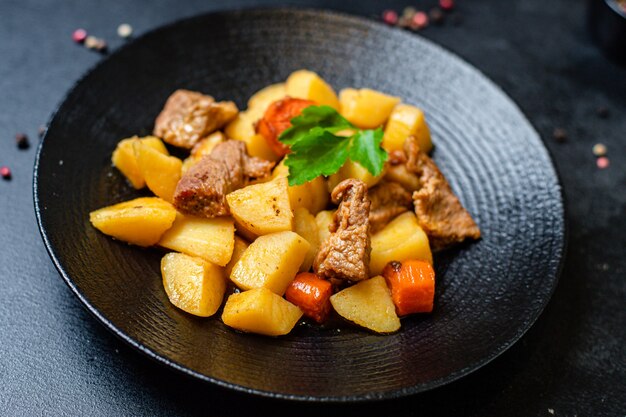 Porción de gulash de verduras asadas con patatas y carne