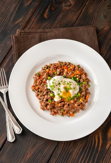 Porción de huevos escalfados con carne picada