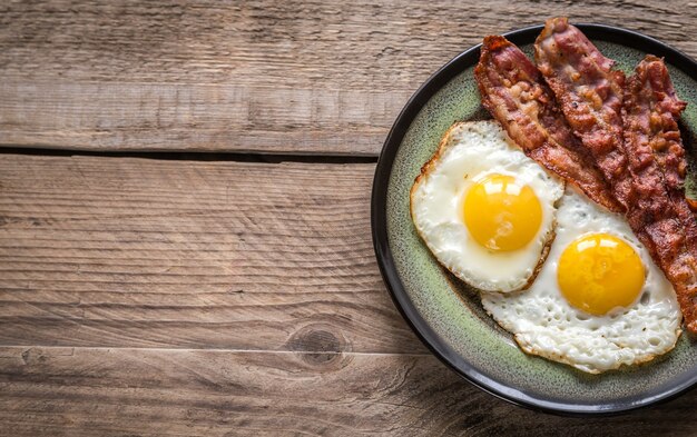 Porción de huevos fritos con tocino