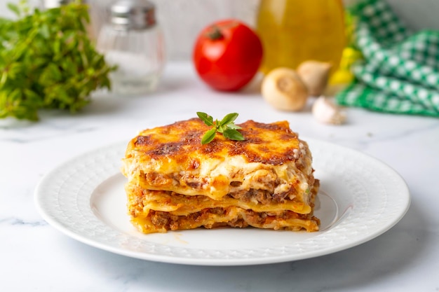 Foto porción de lasaña de carne molida cubierta con queso derretido y adornada con perejil fresco servida en un plato a la vista para un menú