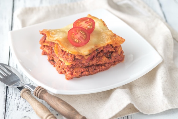 Porción de lasaña en el plato blanco