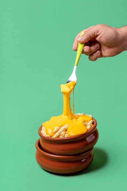 Foto porción de macarrones con queso y queso cheddar derretido comer macarrones con queso con un tenedor