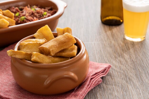 Foto una porción de mandiocas fritas mandiocas en una mesa de madera comida tradicional brasileña