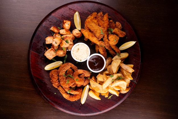 porción de mariscos con pescado panado y camarones y salmón a la parrilla con patatas fritas vista de arriba