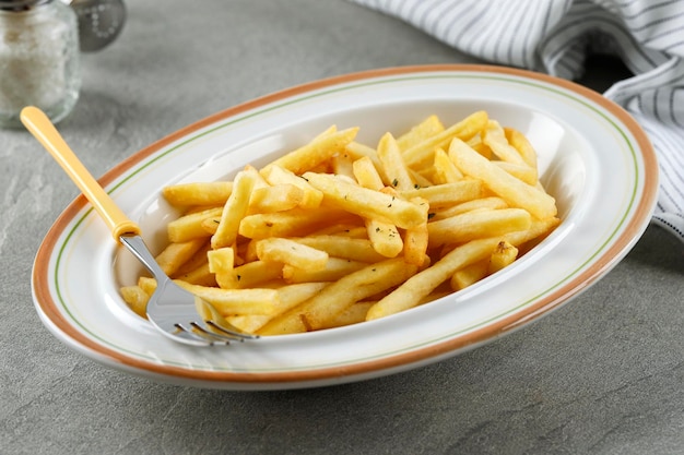 Porción de papas fritas en plato blanco Cerrar concepto Fast Food