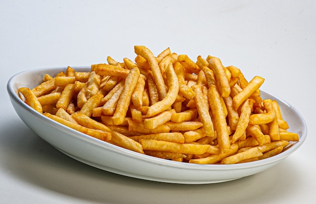 Porción de papas fritas servidas en un plato sobre fondo blanco.