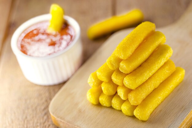 Porción de polenta, palitos fritos típicos de Brasil, servidos con salsa de tomate o salsa de tomate