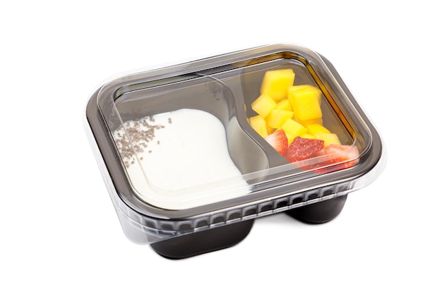 Porción de postre de yogur con fresa y mango en un tazón de plástico