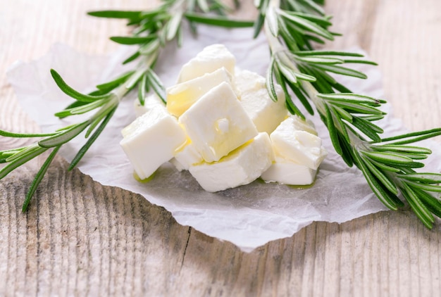 Porción de queso feta en el fondo de madera con romero