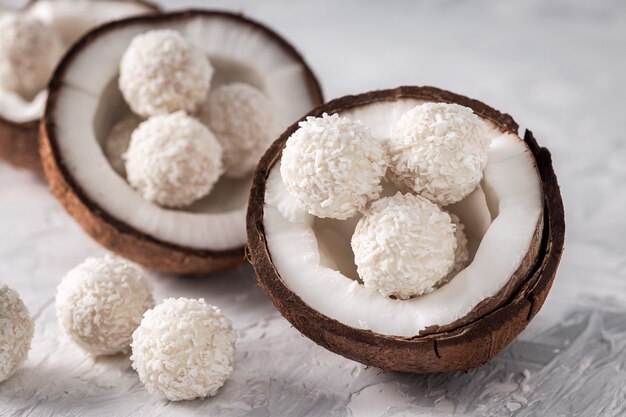 Porciones de bolas de caramelo de coco de chocolate blanco en coco crudo agrietado