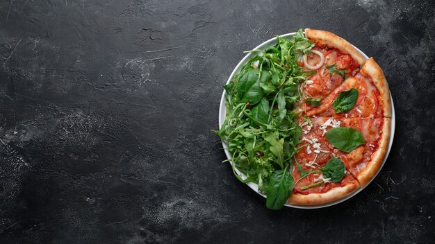 Porciones de pizza italiana sobre fondo oscuro con espinacas