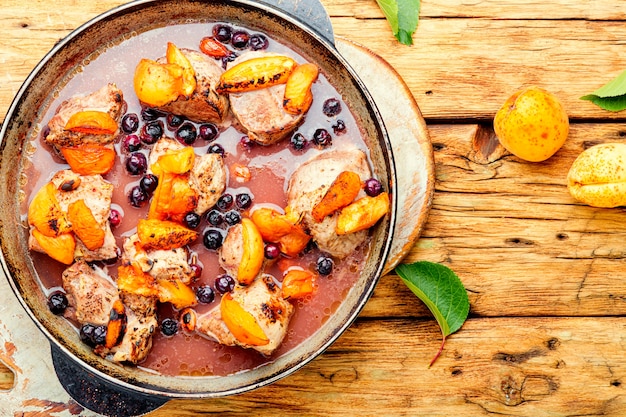 Porco assado em vinho tinto com damasco e groselha preta.