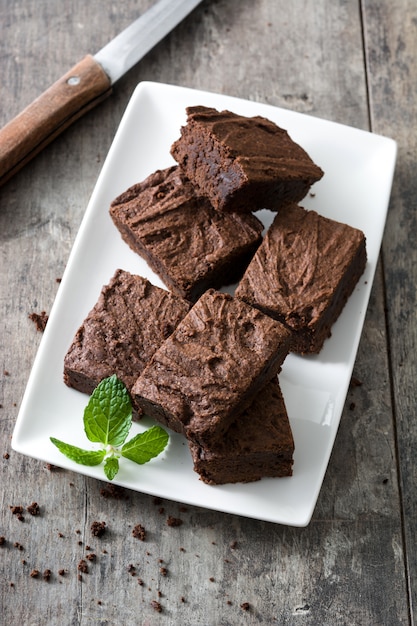 Porções de brownie de chocolate no fundo de madeira