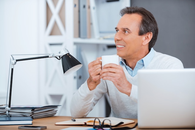 Porque la creación debe ser inspiración. Hombre maduro pensativo sosteniendo la taza de café