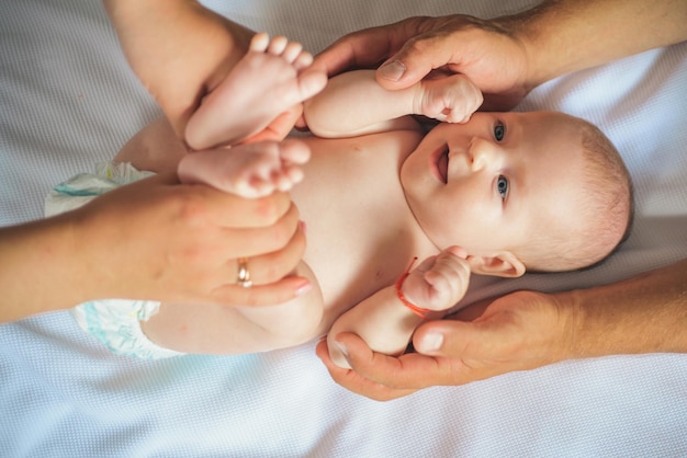 Porque el cuidado comienza en la familia Bebé recién nacido al que los padres le dan masajes Cuidado del bebé recién nacido Paternidad feliz La paternidad es un desafío Permítase ser un padre feliz para su hijo y para usted mismo