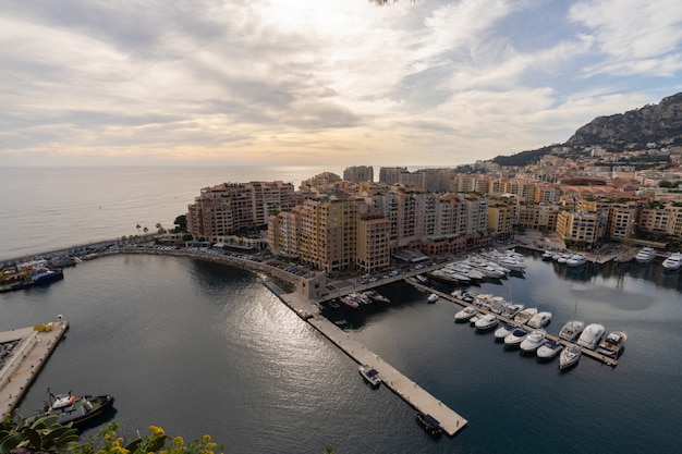 Port de Fontvieille en la costa de Azur en salida del sol con la nube del cielo azul. Preciosos apartamentos y puerto con yates de lujo en la bahía, Monte Carlo, Mónaco, Europa