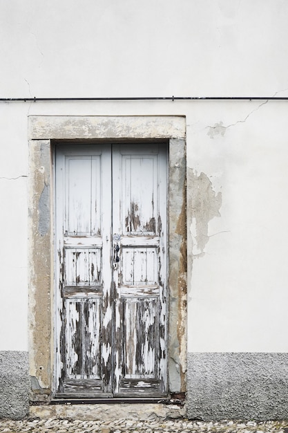 Porta da frente vintage com pintura descascada e parede com fachada de casa velha danificada pelo tempo em Bérgamo, Itália