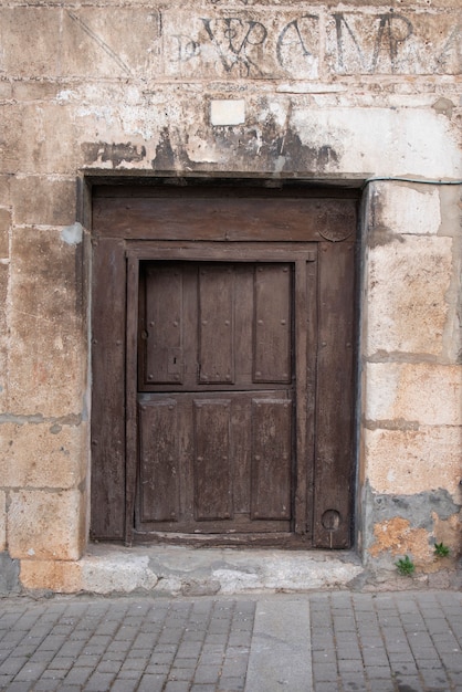 Porta de acesso à casa em madeira, antiga e em madeira trabalhada.