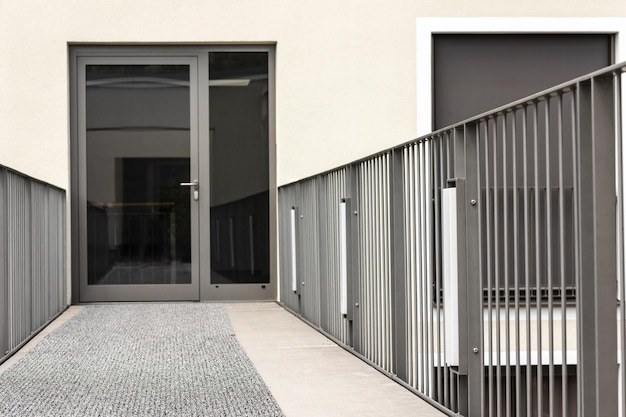 Porta de entrada da varanda ou terraço com grades. Porta de entrada de vidro moderna do edifício