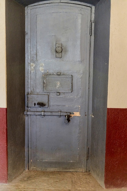 Porta de ferro da cela de prisão com janela de observação e ferrolhos de aço. porta de prisão de metal