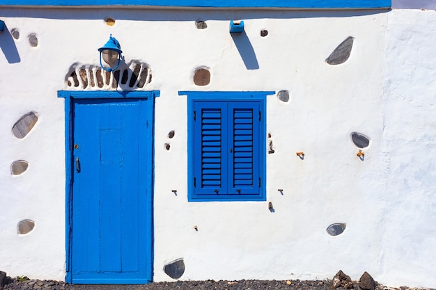 Porta de madeira azul em uma parede branca da casa em Fuerteventura