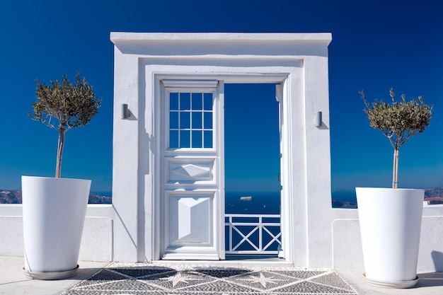 Porta de madeira branca idílica azul e branca ou entrada para vista para o mar na ilha de Santorini, na vila de Oia, Grécia Bem-vindo a um resort de férias