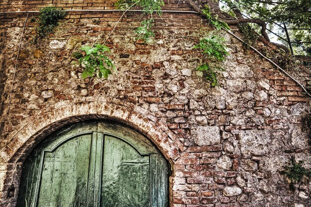 Foto porta de madeira em uma parede de tijolos em hdr em siena itália