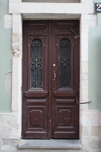 Porta de madeira marrom vintage com forjamento de elementos.