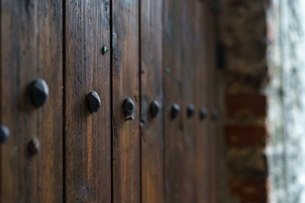 Porta de madeira medieval com ferragens decorativas de metal.