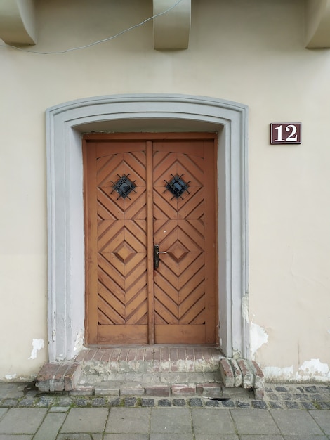 Foto porta de madeira velha na fachada de casas com número