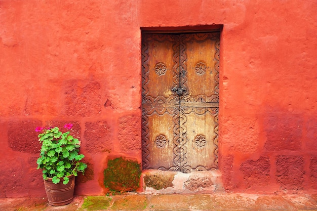 Porta de madeira velha na parede vermelha. Mosteiro de Santa Catalina em Arequipa, Peru