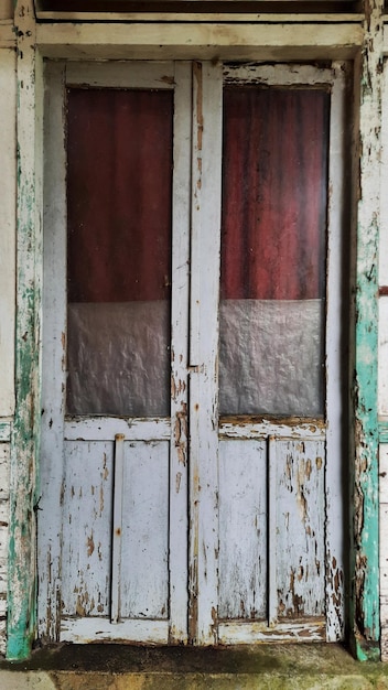 Porta de madeira velha porosa em casa na aldeia