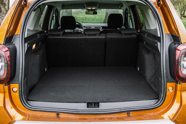 Foto porta-malas enorme, limpo e vazio no interior de um suv compacto moderno. vista traseira de um carro suv com porta-malas aberta. interior da mala do carro.